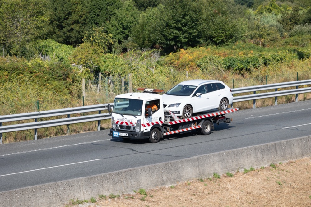 Grúa transportando un vehículo por la autovía